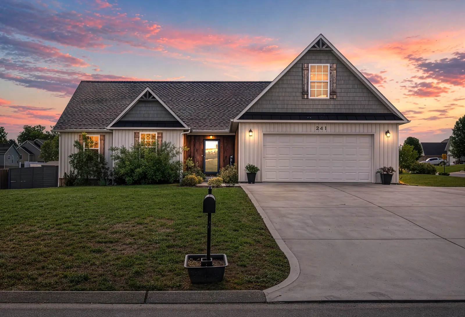 Home with a two-car garage and a steep front gable at twilight, the sky in pink and gold
